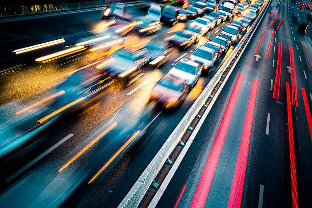Car headlights and tail lights streaking along a highway at night