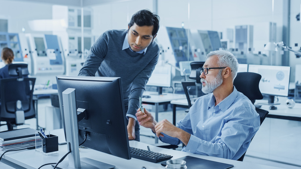 Engineers working together at a workstation